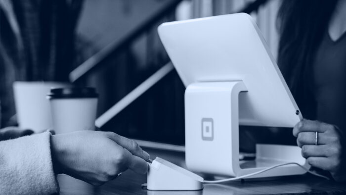 A woman pays using a card machine.