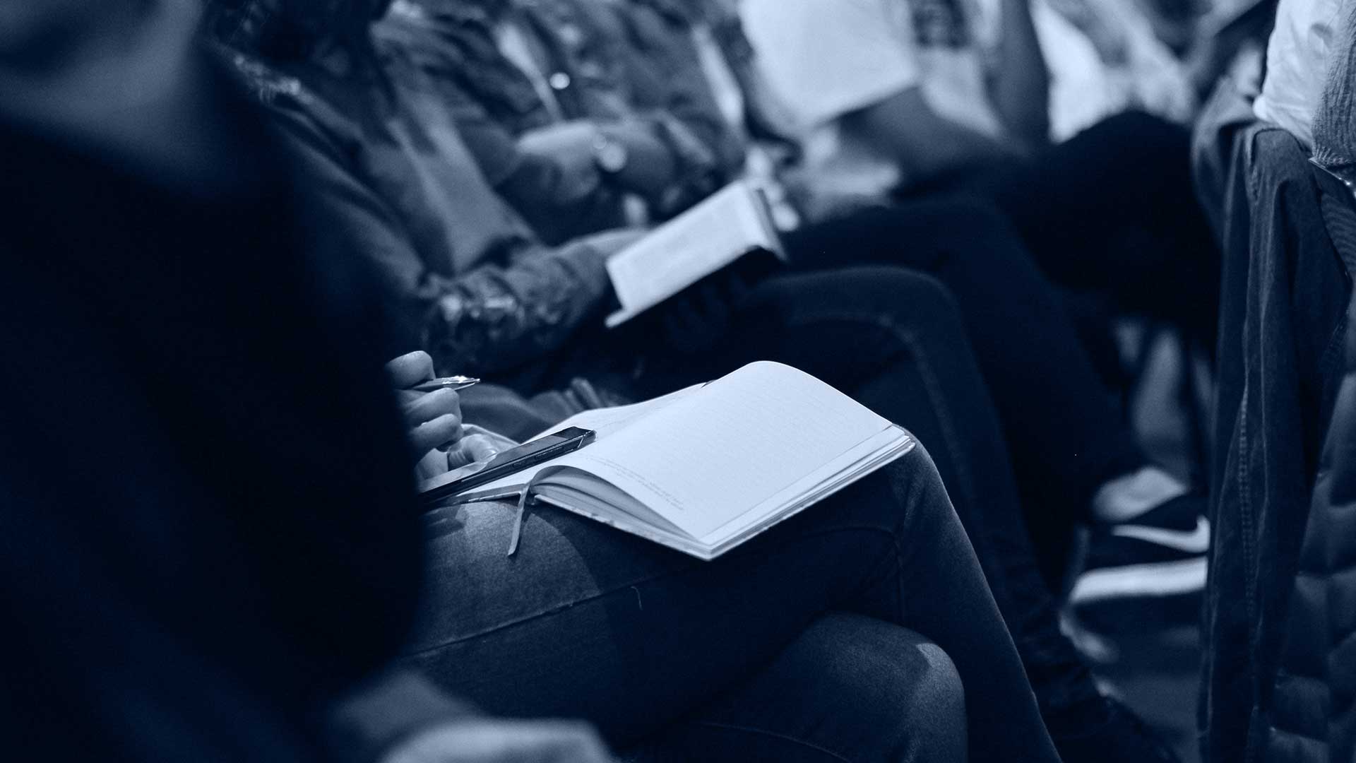 People taking notes at a seminar.